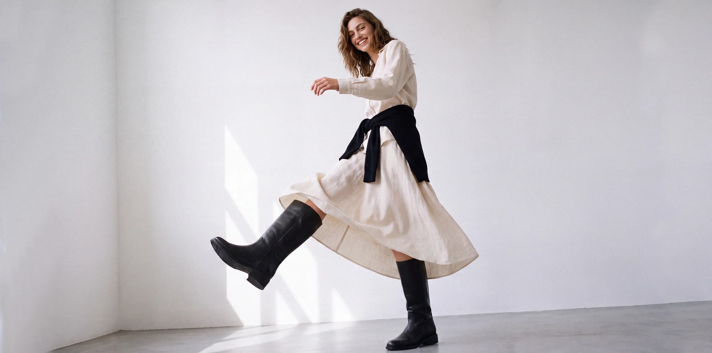 Lilac Blonde fashion ecommerce campaign featuring a model in a white dress and black boots